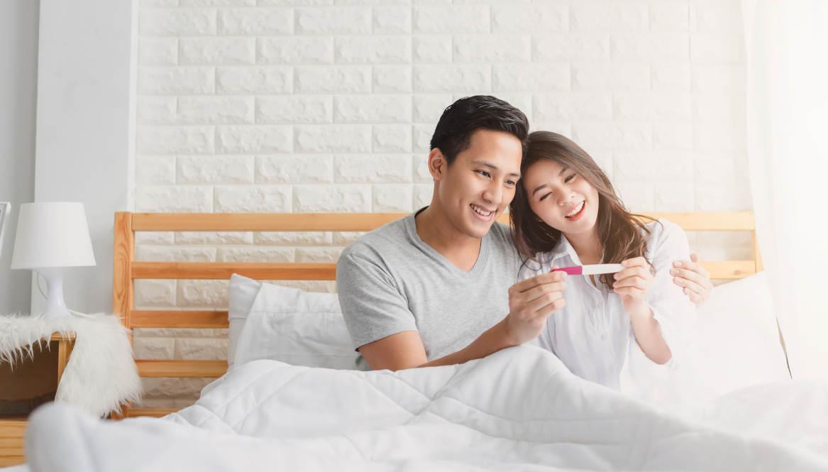 Pasangan suami istri melihat hasil tes kehamilan