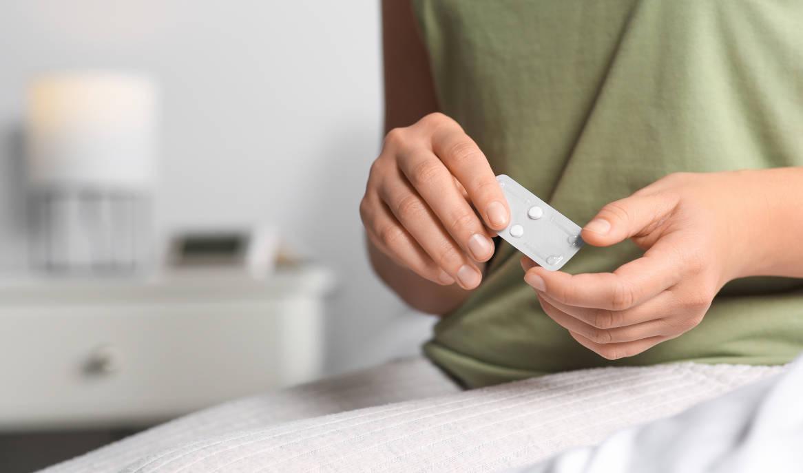 Wanita memegang pil kontrasepsi darurat