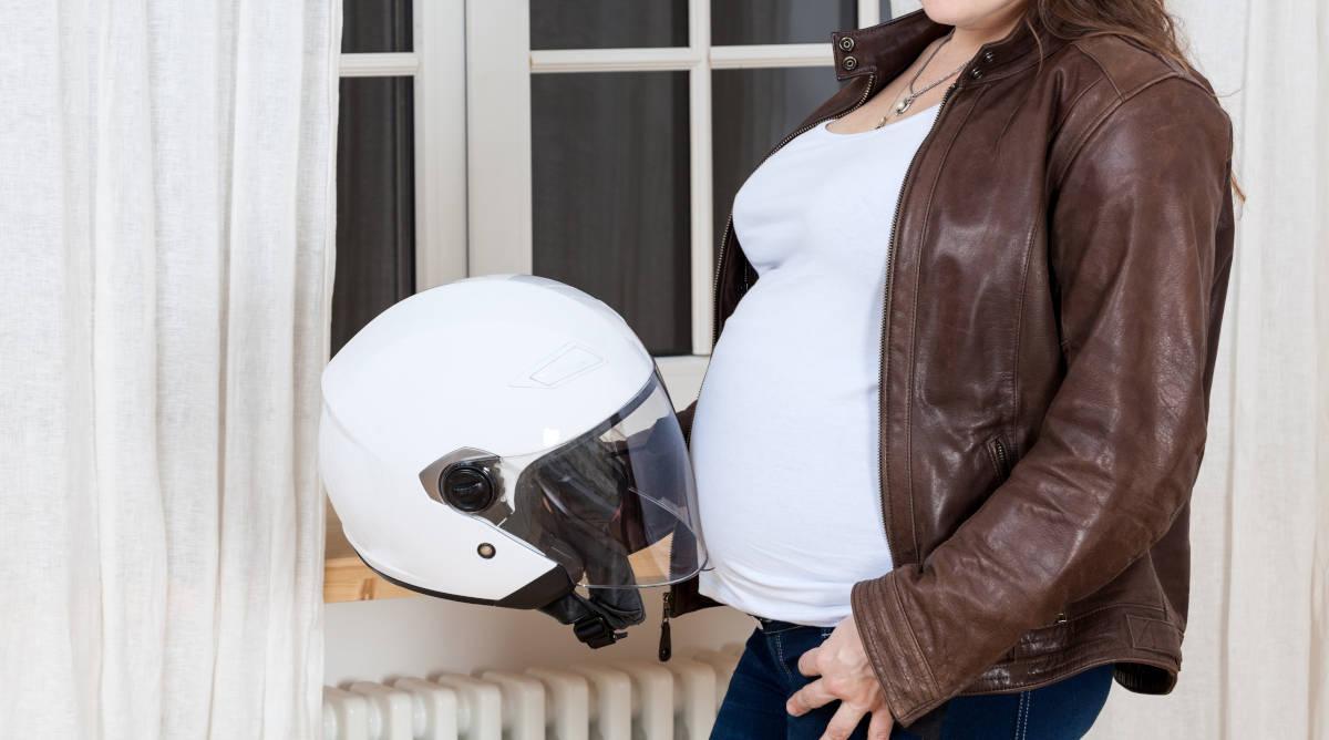 Ibu hamil sedang naik motor