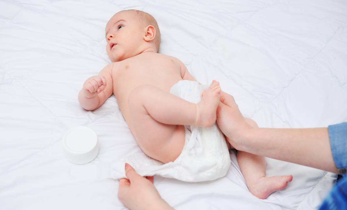 Ibu sedang mengganti popok bayi