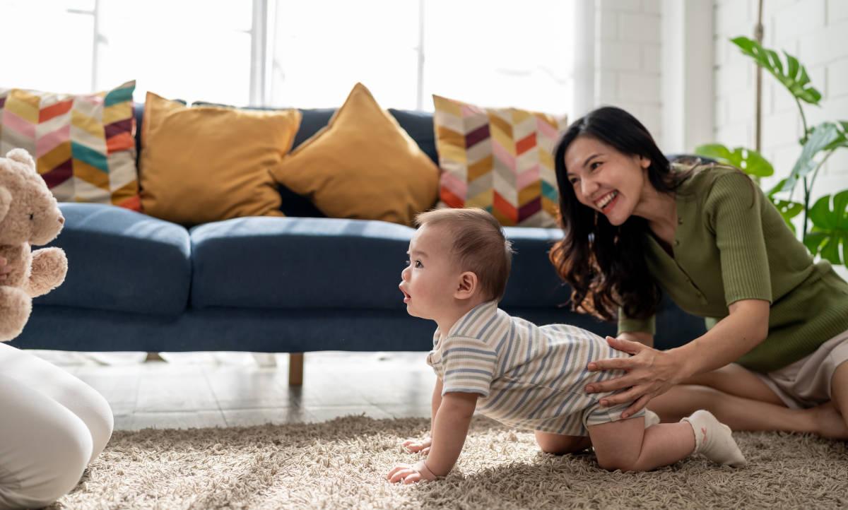 Seorang ibu sedang melatih anak merangkak