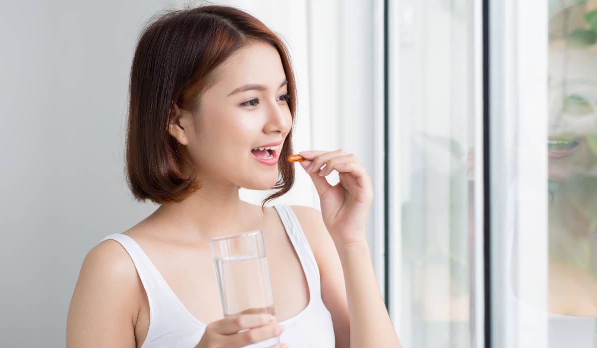 Seorang wanita sedang mengonsumi vitamin D