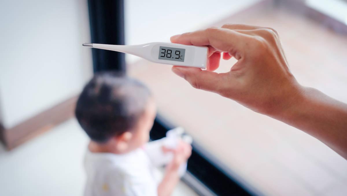 Ibu sedang membaca hasil suhu di termometer